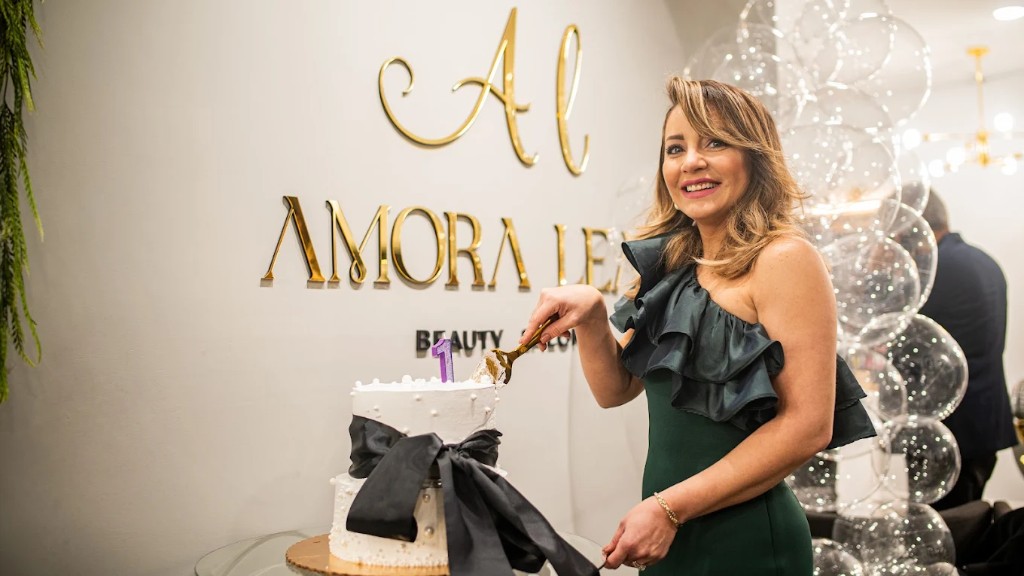 Founder celebrating Amora Leah Beauty Salon first anniversary with cake