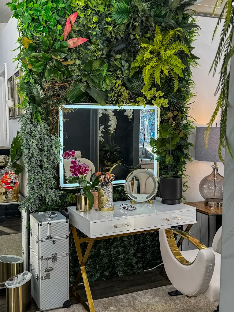 Illuminated makeup vanity with botanical green wall at Amora Leah